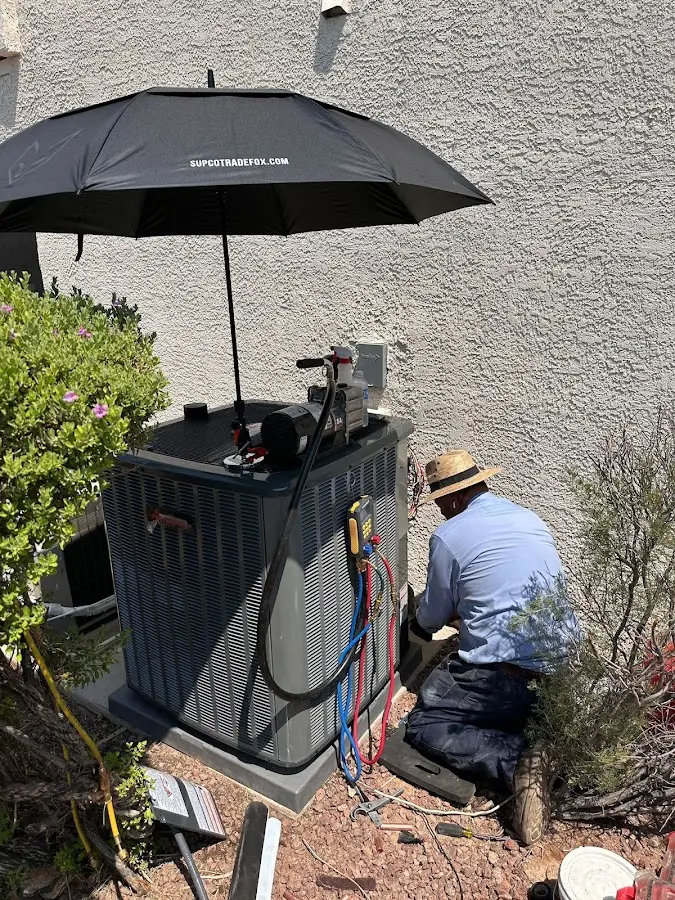 HVAC technician performing outdoor AC maintenance in Rogers